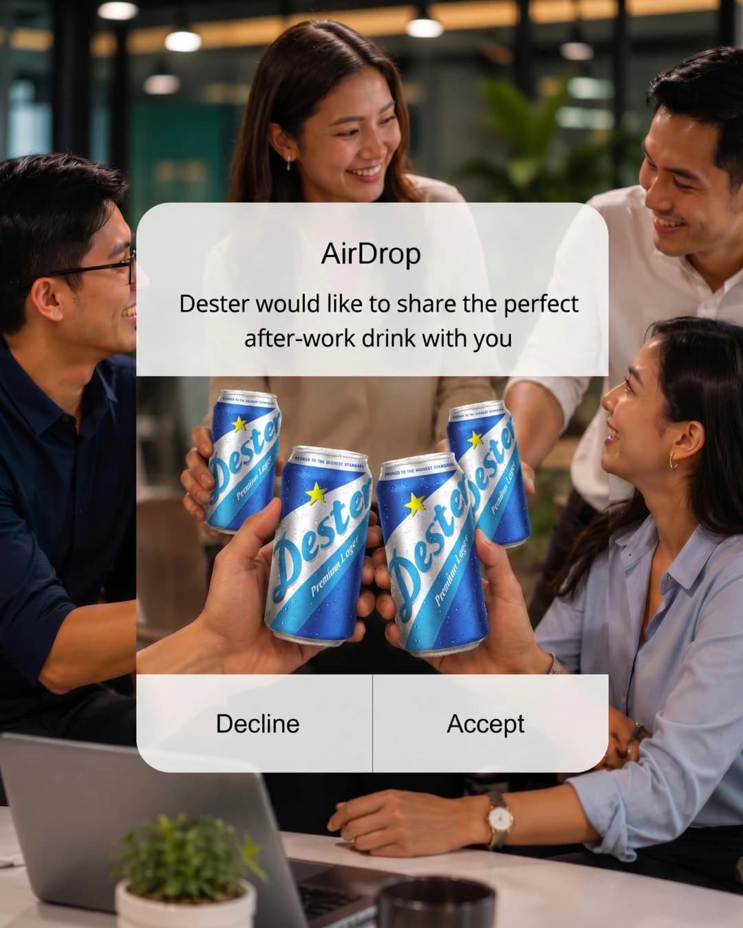Coworkers in an office toast with blue cans; AirDrop share prompt with Decline and Accept buttons.